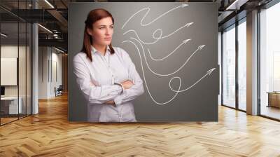 Attractive teenager looking at multiple curly arrows Wall mural