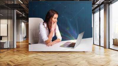 beautiful woman sitting at desk and typing on laptop with abstra Wall mural