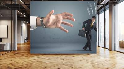 Business person getting away from a big hand Wall mural