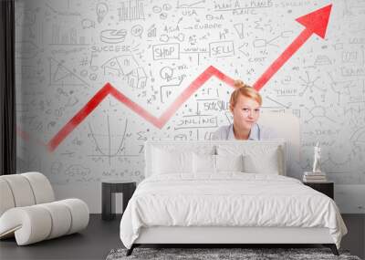 Business woman sitting at table with market diagrams Wall mural