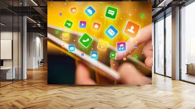 Businessman hand using tablet with flying application icons around
 Wall mural