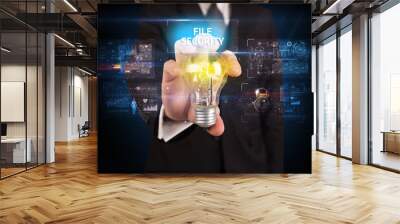 Businessman holding a light bulb, online security concept Wall mural