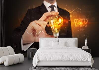 Businessman holding a lightbulb concept Wall mural