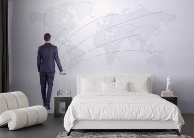 Businessman in dark suit planning his trip in a front of a map
 Wall mural