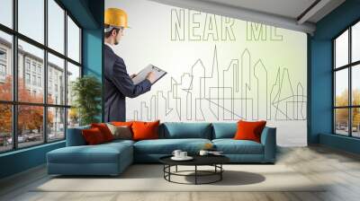 Businessman in hard hat holding blueprint with NEAR ME inscription, engineering and architecture concept Wall mural