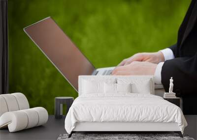 Businessman pressing modern laptop computer on colorful backgrou Wall mural