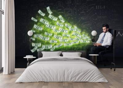 businessman sitting in chair holding tablet with dollar bills co Wall mural