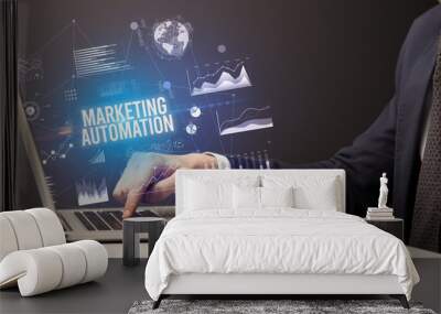 Businessman working on laptop with MARKETING AUTOMATION inscription, new business concept Wall mural