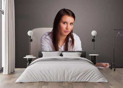 Businesswoman sitting at desk and doing paperwork Wall mural