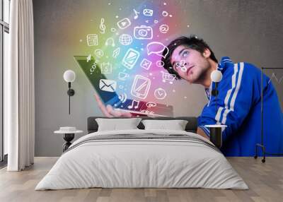 Casual man holding laptop with colorful hand drawn multimedia sy Wall mural