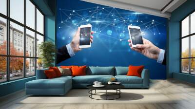 Close up of two hands holding smartphones and sharing business data Wall mural