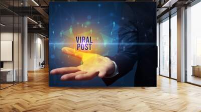 Elegant hand holding VIRAL POST inscription, social networking concept Wall mural