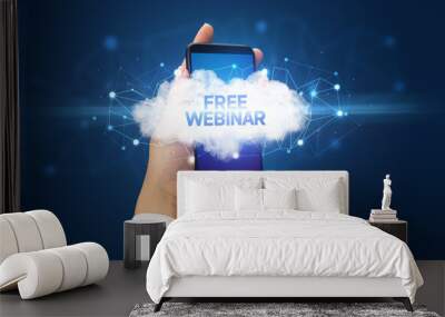 Female hand touching smartphone with FREE WEBINAR inscription, cloud business concept Wall mural