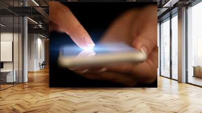 Finger touching phone with dark background with copyspace Wall mural