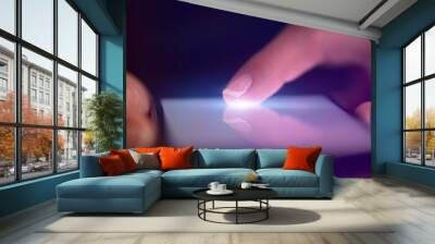 Finger touching phone with dark background with copyspace
 Wall mural