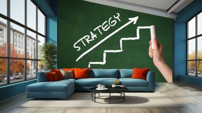 Hand drawing STRATEGY inscription with white chalk on blackboard, business concept Wall mural