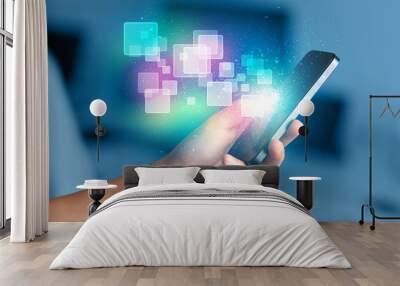 hand holding smart phone with abstract glowing squares Wall mural