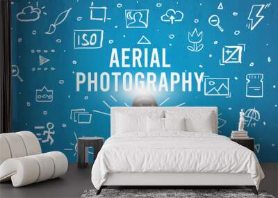 Hand taking picture with digital camera and AERIAL PHOTOGRAPHY inscription, camera settings concept Wall mural