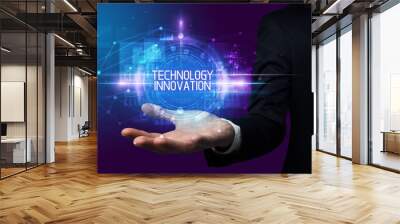 Man hand holding TECHNOLOGY INNOVATION inscription, technology concept Wall mural