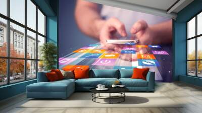 man holding smart phone with colorful application icons Wall mural