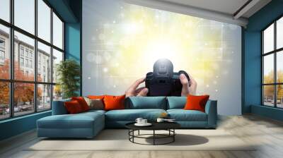 Naked hand taking picture with digital camera and glowing flash concept Wall mural