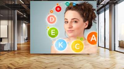 Pretty young girl with colorful vitamin icons and symbols Wall mural