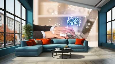 Side view of a business person working on laptop with GROSS PROFIT inscription, modern business concept Wall mural