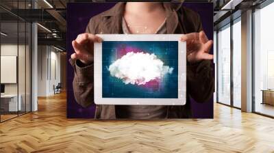 Woman holding tablet with cloud graphic Wall mural