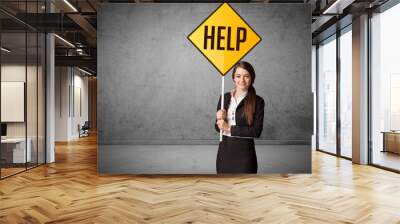 Young business person holding road sign Wall mural