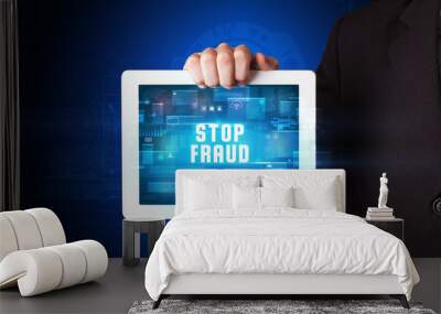 Young business person working on tablet and shows the digital sign: STOP FRAUD Wall mural