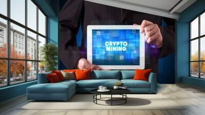 Young business person working on tablet and shows the inscription: CRYPTO MINING Wall mural