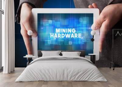 Young business person working on tablet and shows the inscription: MINING HARDWARE Wall mural