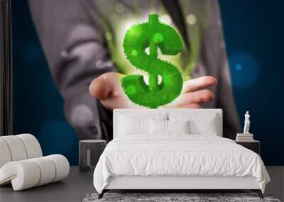 Young businessman presenting green glowing dollar sign Wall mural