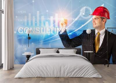 Young businessman with helmet drawing CONSULTING inscription, modern business technology concept Wall mural