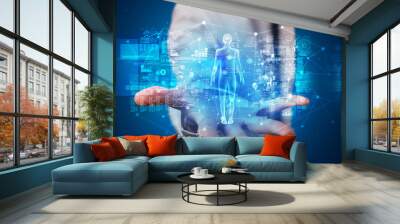 Young person holding hologram projection displaying health related graphs and symbols
 Wall mural