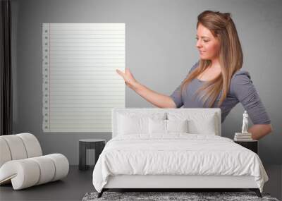 Young woman holding white paper copy space with diagonal lines Wall mural