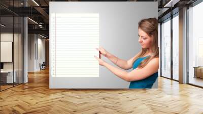 Young woman holding white paper copy space with diagonal lines Wall mural