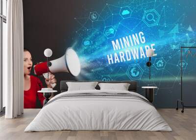 Young woman shouting in megaphone with MINING HARDWARE inscription, Modern technology announcement concept Wall mural