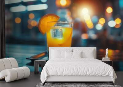 A glass of juice and fresh orange fruit closeup view on table in a restaurant bar Wall mural