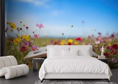 An opened book in wild flower field in wild with variable colors in Spring. Spring seasonal concept. Wall mural