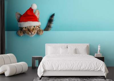 cute baby cat wearing red christmas cap peeping with plain background Wall mural