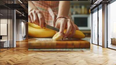 Hand slicing fresh banana fruit closeup view Wall mural