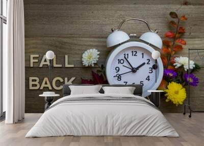 FALL BACK Daylight Saving Time concept with white alarm clock and fresh fall flowers foliage on hand painted gray wood board flat lay Wall mural