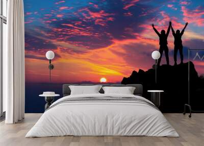 Silhouetted Hikers Celebrating on Mountain Peak with Dramatic Sunset and Colorful Sky Wall mural