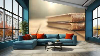 Two old books are stacked on top of each other on a wooden table Wall mural