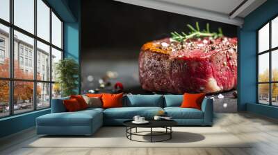 A juicy, raw beef steak seasoned with salt, spices, and herbs sits on a dark surface. Wall mural