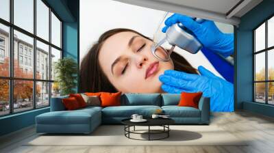 Process of facial CO2 laser resurfacing. Cosmetologist removes wrinkles and scars using laser from face of attractive girl. Wall mural