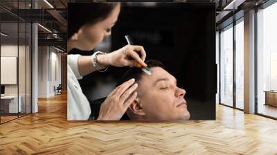 Straight razor cut man hair in barbershop. Attractive woman barber making hairstyle for handsome man. Wall mural