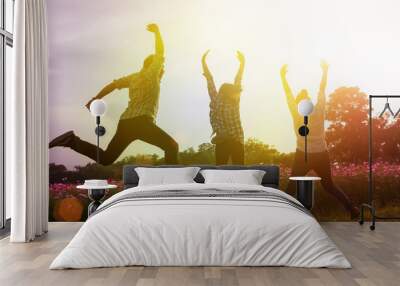 Group of friend happily jumping outdoor, sunset time Wall mural