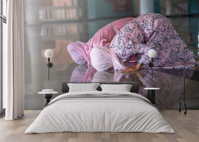 Hands of two muslim woman on the reflection floor praying in traditional clothes. Wall mural